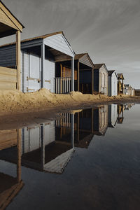 Houses on beach by buildings against sky