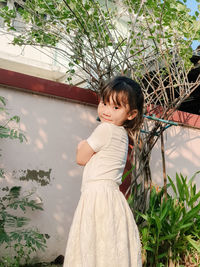 Portrait of smiling girl standing against plants