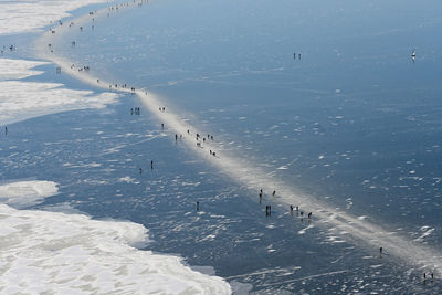 High angle view of people skiing on snow covered land