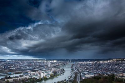 Aerial view of cityscape against cloudy sky