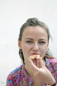Close-up of a pretty young woman biting a piece of toast in a bar terrace