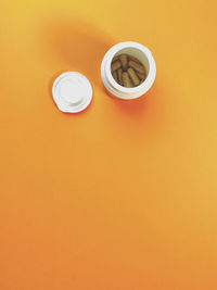 High angle view of coffee on orange table