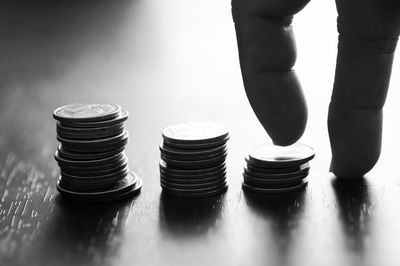 Cropped hands climbing coins stacked on table