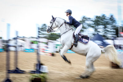 Blurred motion of man riding horse