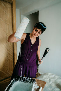 Woman standing against the wall at home