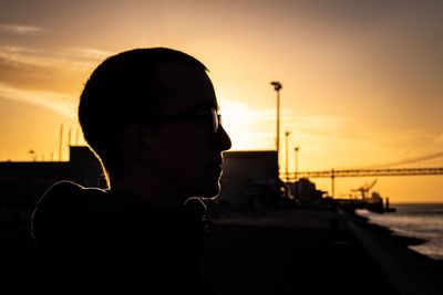 Portrait of man looking at camera against sky during sunset