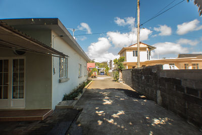 Street amidst houses against sky