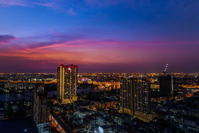 High angle view of illuminated buildings against sky at night