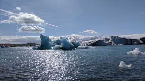 Scenic view of ice floating on sea against sky