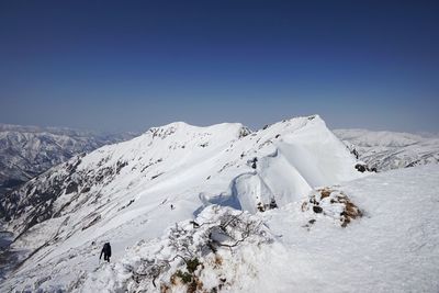 Scenic view of snowcapped mountains against clear blue sky