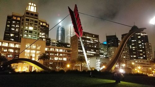 Illuminated city against sky at night