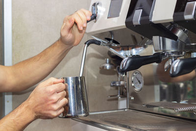 Cropped image of man pouring coffee in glass