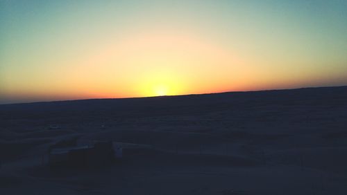 Scenic view of desert against clear sky during sunset