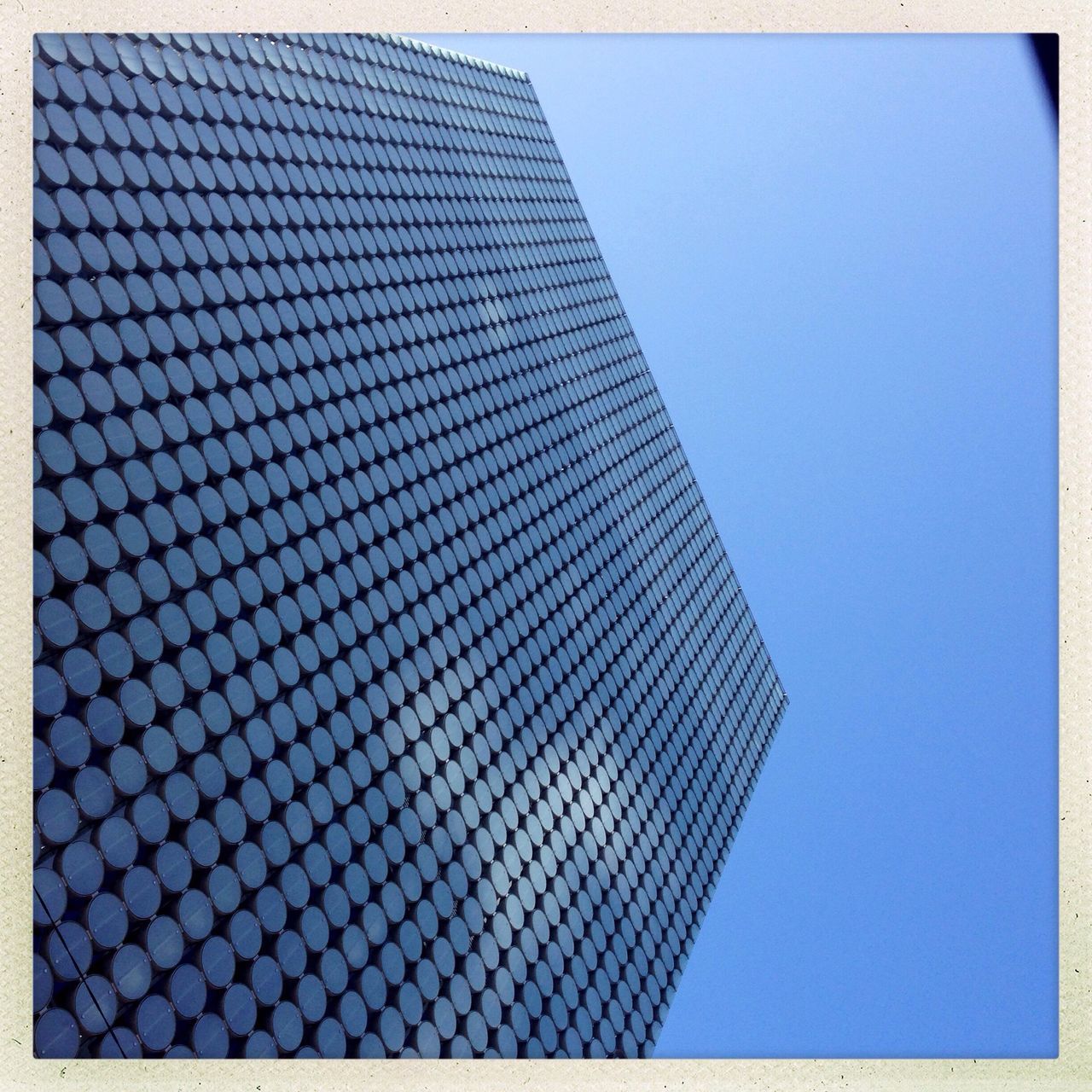 transfer print, low angle view, architecture, building exterior, clear sky, built structure, auto post production filter, blue, modern, pattern, copy space, building, office building, city, day, repetition, outdoors, no people, tower, skyscraper