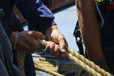 Close-up of person holding ropes