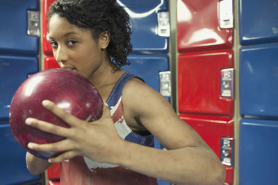 A young women holding a bowling ball.