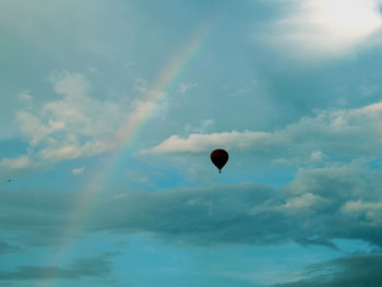 View of hot air balloon with rainbow against sky