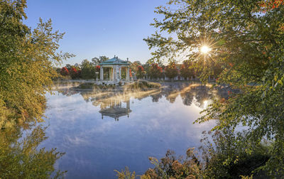 Reflection of trees and buildings in lake against sky