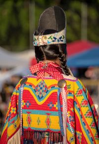 Rear view of woman standing against multi colored umbrella