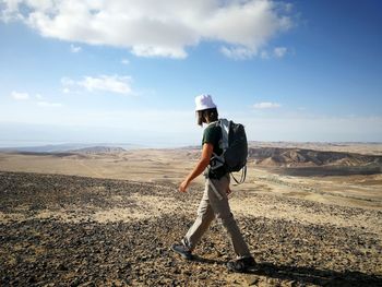 Side view of man with backpack walking on land