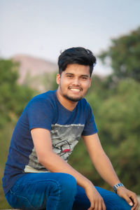 Portrait of smiling young man sitting outdoors