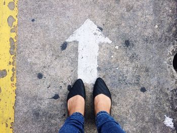 Low section of woman standing on road