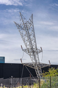 Low angle view of communications tower against cloudy sky