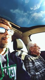 Portrait of woman sitting in car against sky