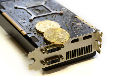 Close-up of bitcoins on computer equipment over white background