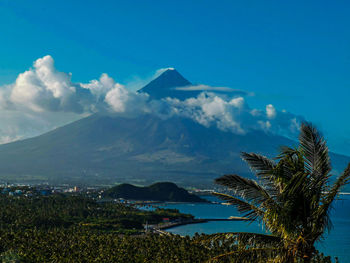 Scenic view of sea and mountains against blue sky