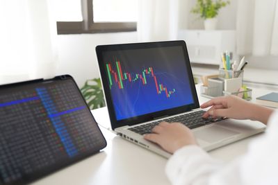 Midsection of woman using laptop on table