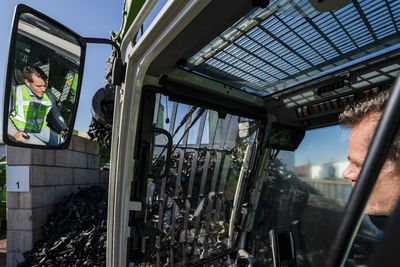 Mature man operating excavator at recycling plant