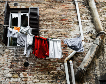 Clothes drying on clothesline against brick wall