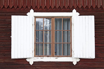 An old wooden window with shutters is reminiscent of a chalet