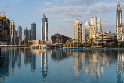 Reflection of buildings in city against sky