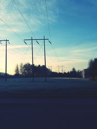 Electricity pylon against cloudy sky