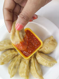 Close-up of hand holding food in plate