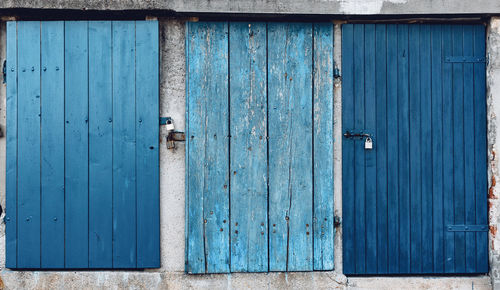 Front view of old wooden doors with locks.