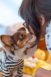 Side view of young woman kissing dog 