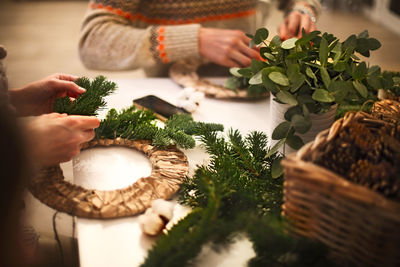 Midsection of woman preparing christmas decoration on table