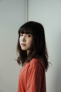 Portrait of young woman against white background