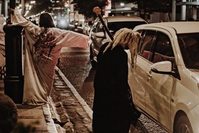 Rear view of people walking on street in city