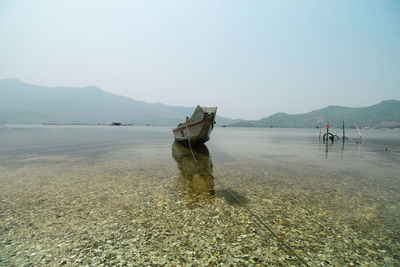 Scenic view of fishing boat at sea against clear sky