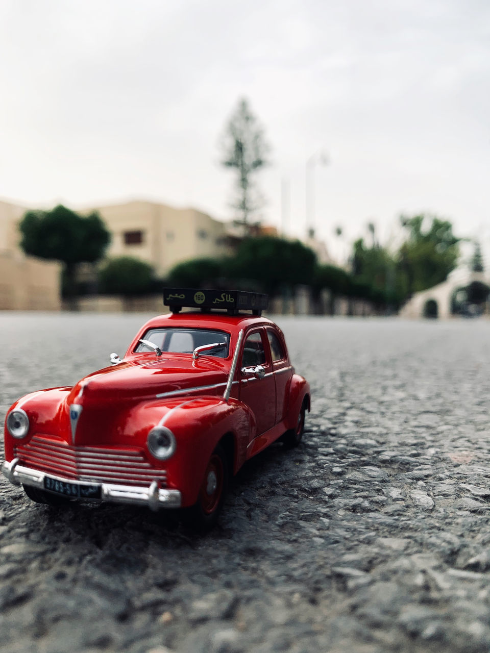 TOY CAR ON STREET AGAINST SKY