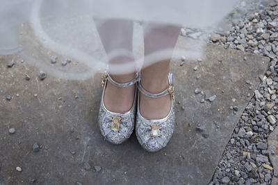  girl standing on ground with diamonds shoes