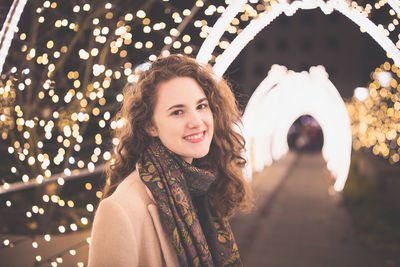 Young woman outdoors, christmas lights in the background. winter holidays season