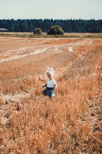 High angle view of cute girl standing on grassy field 