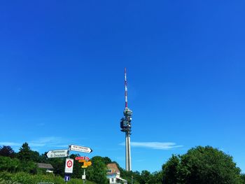 Low angle view of communications tower against blue sky