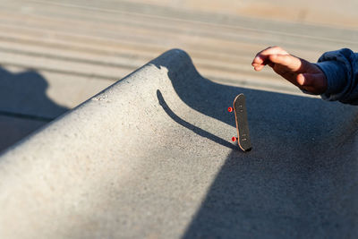 Riding a mini skateboard or fingerboard on outdoors ramp