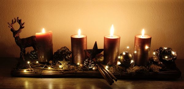 Close-up of illuminated candles on table